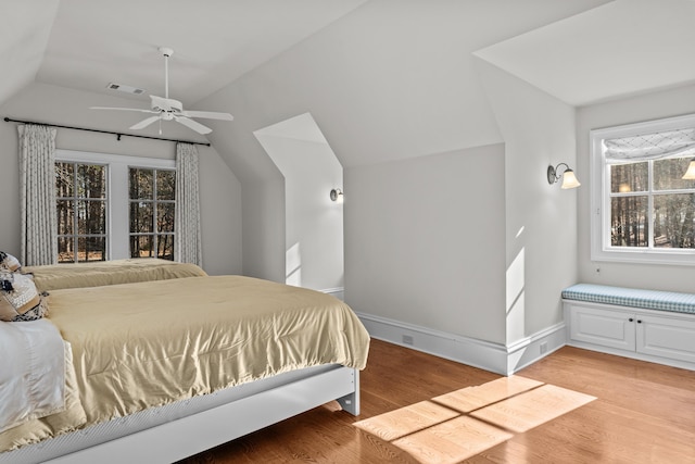 bedroom with ceiling fan, lofted ceiling, and light hardwood / wood-style flooring