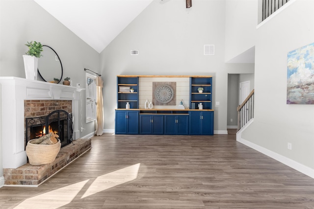 living room with dark wood-type flooring, a fireplace, and high vaulted ceiling