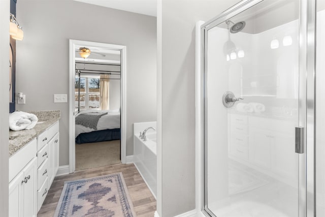 bathroom with vanity, shower with separate bathtub, and hardwood / wood-style floors