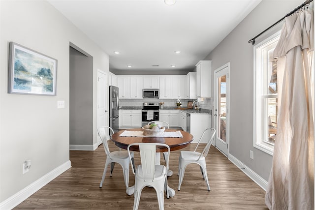 dining space featuring wood-type flooring and sink