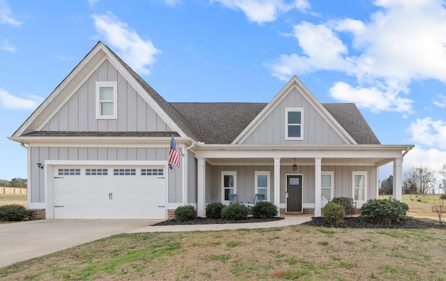 view of front of home featuring a garage, covered porch, and a front yard