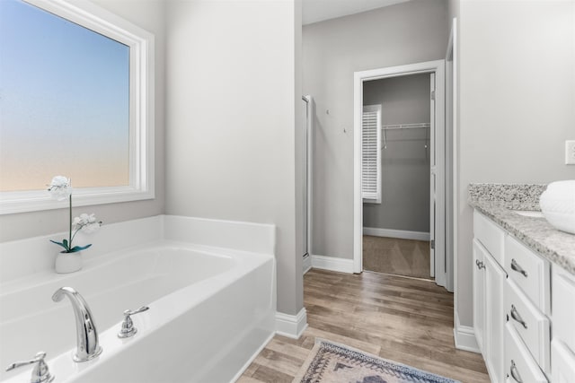 bathroom with vanity, hardwood / wood-style floors, and a bathing tub