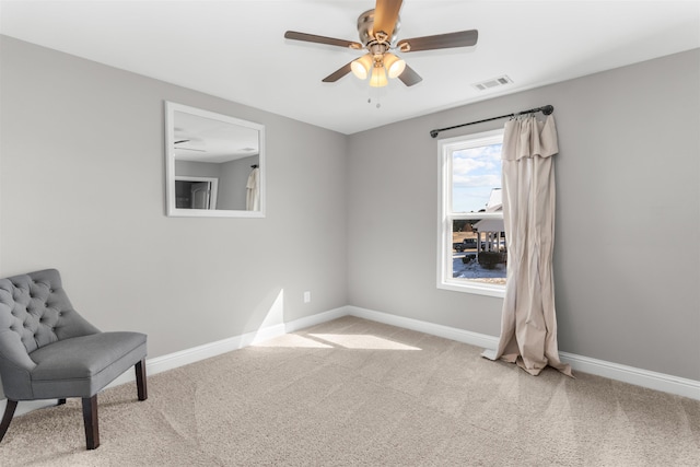 living area featuring light carpet and ceiling fan