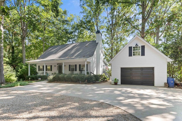 view of front of house with concrete driveway, a chimney, and a garage