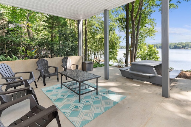 view of patio with a water view and a hot tub