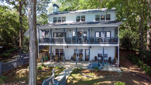 back of property with ceiling fan, a chimney, a balcony, and a patio area