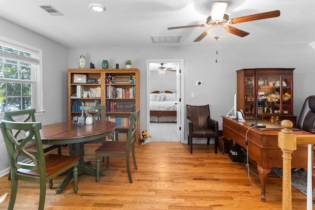 dining space with ceiling fan, light wood-style flooring, and an office area