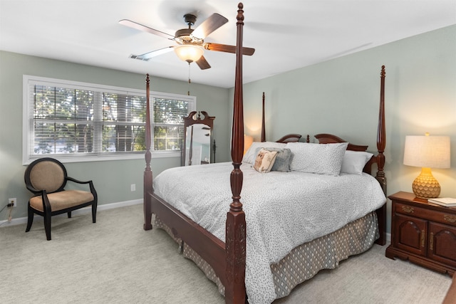 bedroom with light colored carpet, baseboards, and ceiling fan