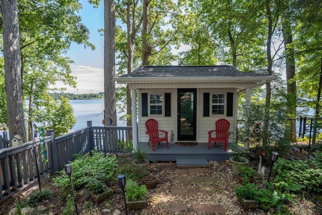view of outbuilding with a water view, fence, and an outdoor structure