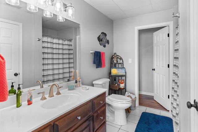 full bathroom featuring tile patterned floors, toilet, vanity, a shower with shower curtain, and a paneled ceiling
