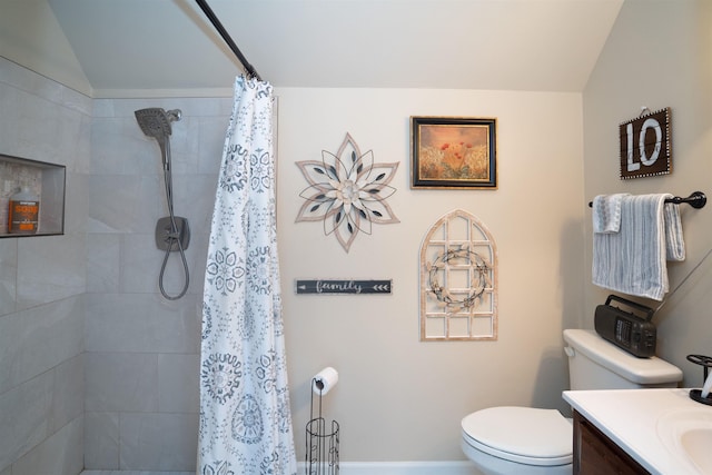 bathroom featuring vaulted ceiling, toilet, vanity, and a tile shower