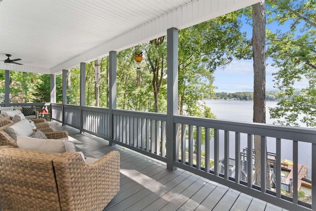 wooden terrace with a water view and a ceiling fan