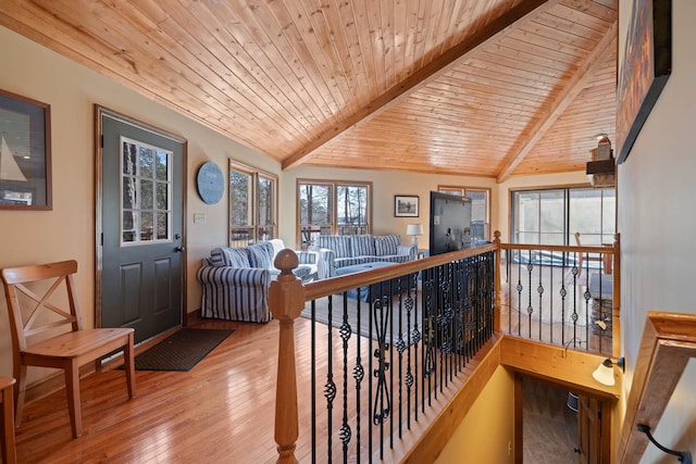hallway with wood ceiling, vaulted ceiling with beams, wood-type flooring, and an upstairs landing