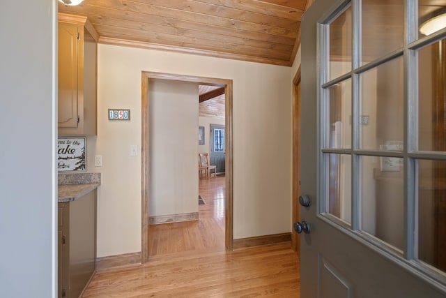 interior space featuring light wood-type flooring, wooden ceiling, and baseboards