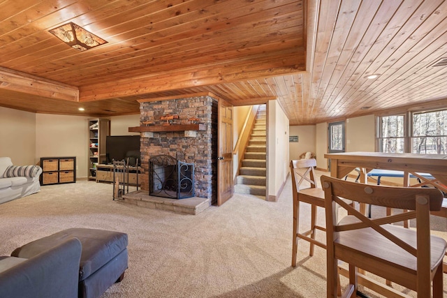 living area featuring stairway, a fireplace, wooden ceiling, and carpet flooring