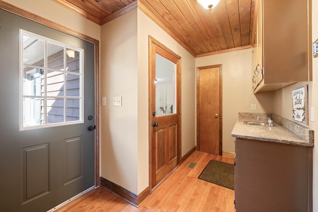 doorway featuring wood ceiling, baseboards, crown molding, and light wood finished floors