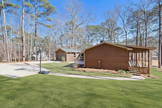 view of property exterior featuring a lawn and a detached garage