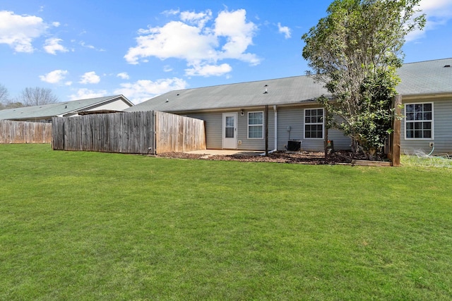 back of property featuring a yard and fence