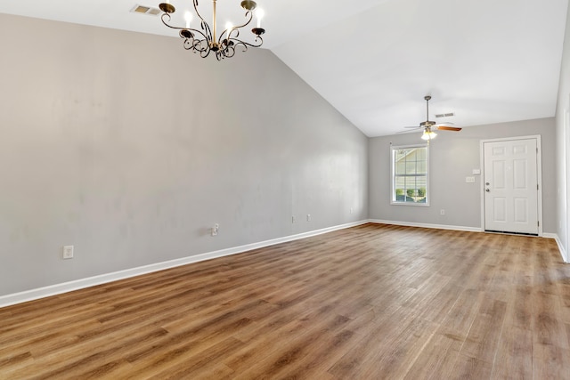 spare room featuring visible vents, baseboards, light wood-style floors, and vaulted ceiling