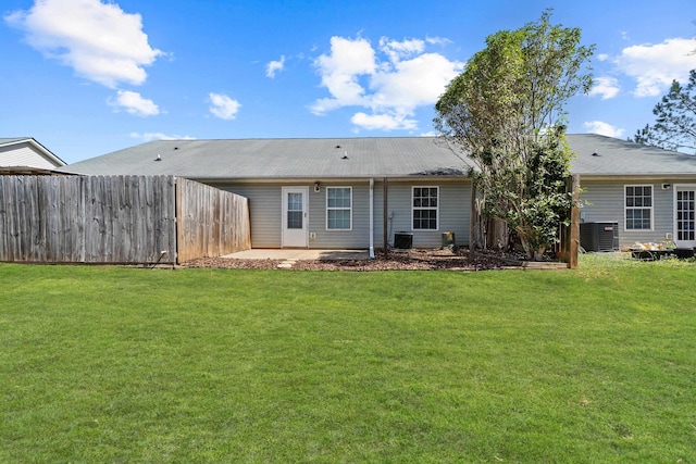 back of house with a yard, fence, and central AC