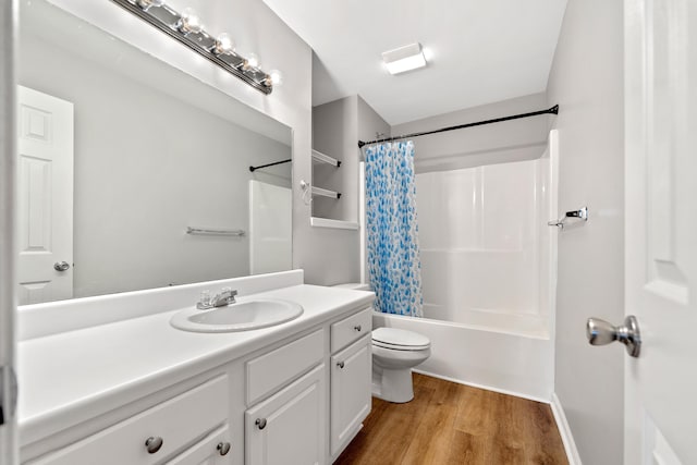 bathroom with vanity, toilet, wood finished floors, and shower / bath combo