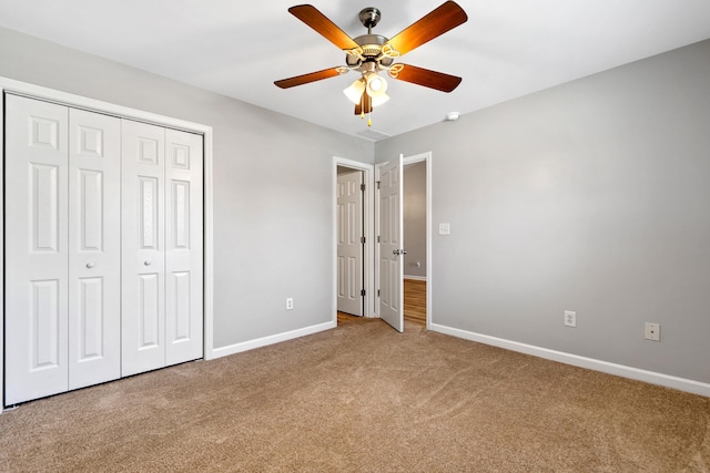 unfurnished bedroom with a closet, baseboards, carpet floors, and ceiling fan