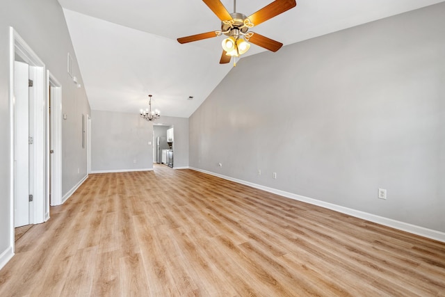 unfurnished living room featuring ceiling fan with notable chandelier, vaulted ceiling, baseboards, and light wood-type flooring