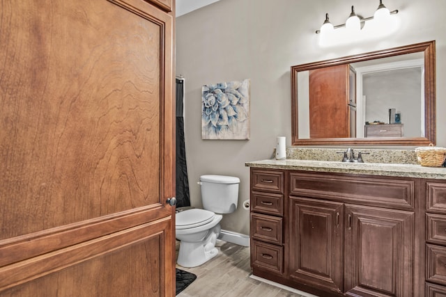 bathroom featuring vanity, hardwood / wood-style flooring, and toilet