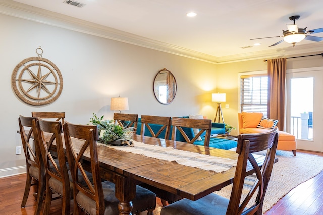 dining area featuring crown molding, dark wood-type flooring, and ceiling fan