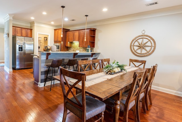 dining room with crown molding and dark wood-type flooring