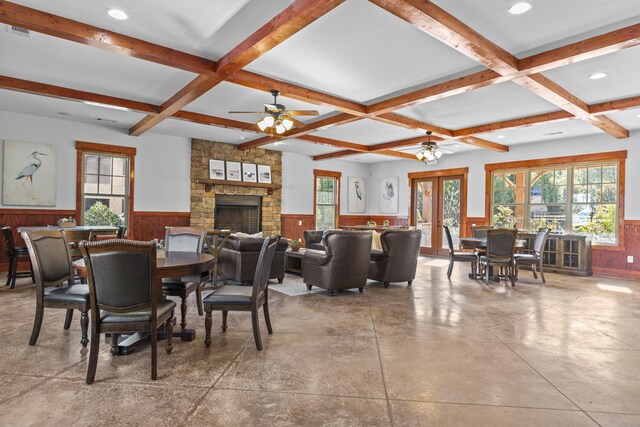 kitchen with appliances with stainless steel finishes, wooden walls, dark stone countertops, a kitchen breakfast bar, and kitchen peninsula