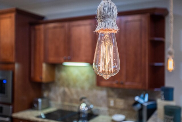 kitchen featuring sink, crown molding, hanging light fixtures, light wood-type flooring, and stainless steel appliances