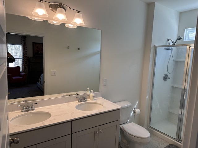 ensuite bathroom with a sink, a shower stall, and toilet