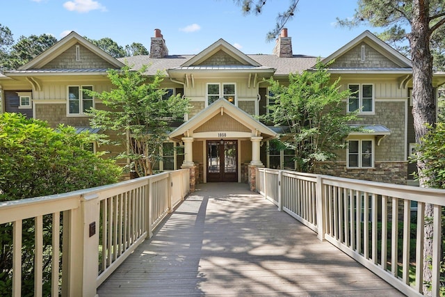 1050A Tailwater, Greensboro, GA 30642 - view of front facade with french doors, a chimney, board and batten siding, and a shingled roof