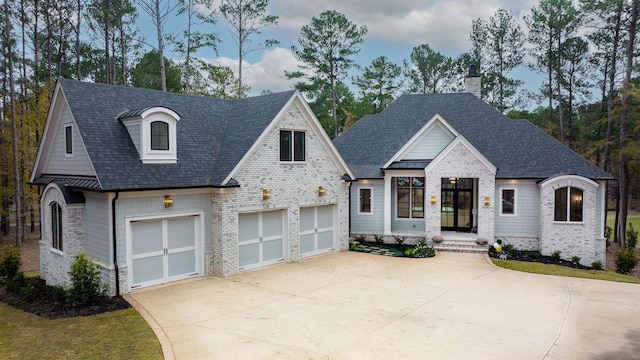 view of front of home featuring driveway, an attached garage, and roof with shingles