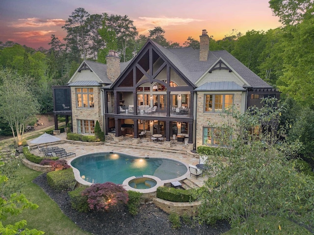 2030 Linger Longer Dr, Greensboro, GA 30642 - back of property at dusk featuring a chimney, a patio area, a balcony, and stone siding
