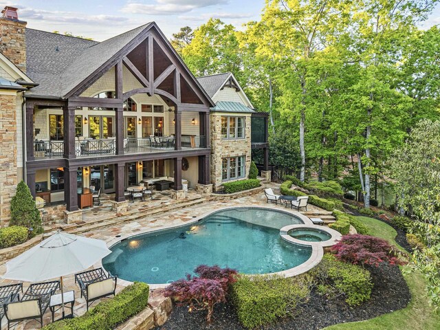 2030 Linger Longer Dr, Greensboro, GA 30642 - back of property featuring a balcony, stone siding, a chimney, a patio area, and a pool with connected hot tub