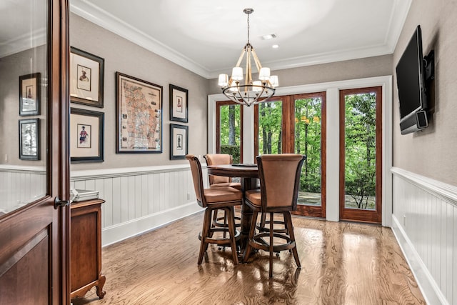 2030 Linger Longer Dr, Greensboro, GA 30642 - dining area featuring an inviting chandelier, light wood-style floors, ornamental molding, a wainscoted wall, and visible vents
