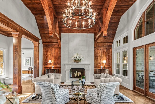 2030 Linger Longer Dr, Greensboro, GA 30642 - interior space featuring ornate columns, wood finished floors, high vaulted ceiling, and a notable chandelier