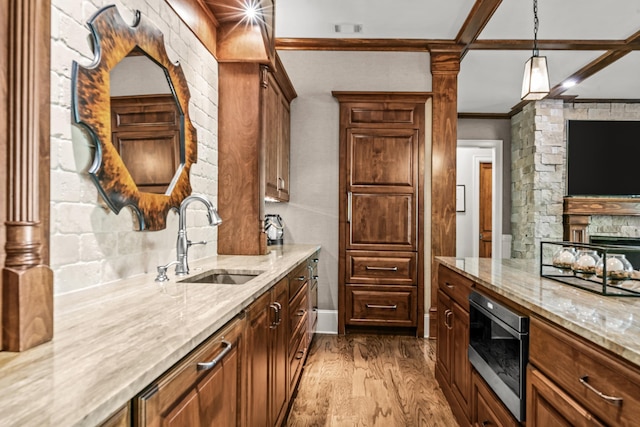2030 Linger Longer Dr, Greensboro, GA 30642 - kitchen with light stone countertops, stainless steel microwave, light wood finished floors, a sink, and pendant lighting