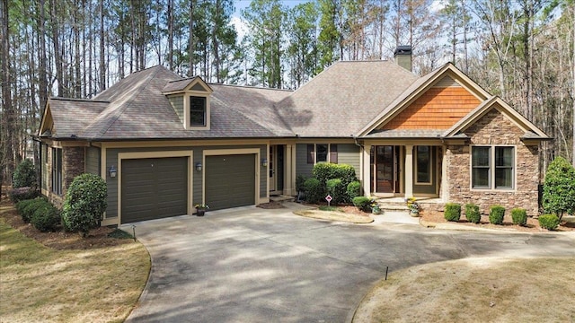 craftsman inspired home with a garage, stone siding, and concrete driveway