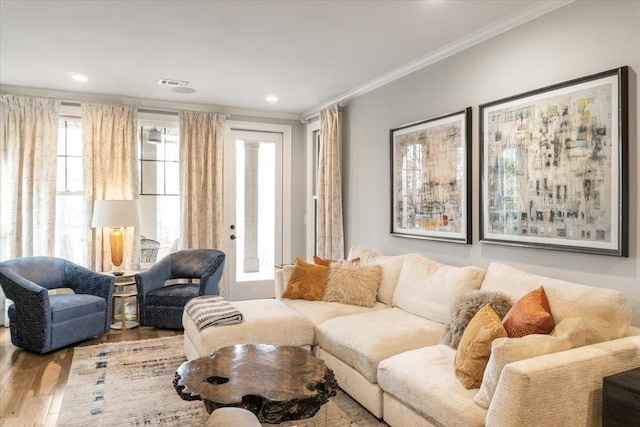 living room with recessed lighting, visible vents, crown molding, and wood finished floors