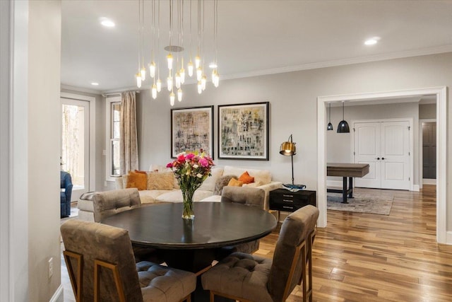 dining area featuring light wood-style floors, baseboards, ornamental molding, and recessed lighting