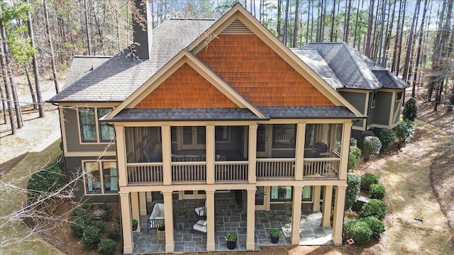 rear view of house featuring a sunroom, a patio, and a chimney