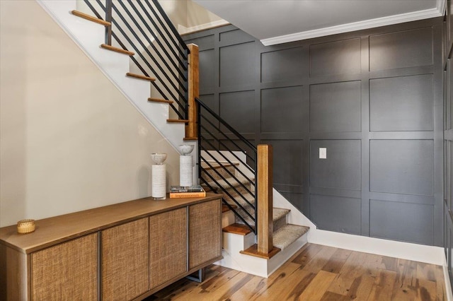 stairway featuring a decorative wall and wood finished floors