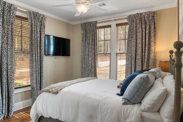 bedroom featuring ornamental molding, multiple windows, and visible vents