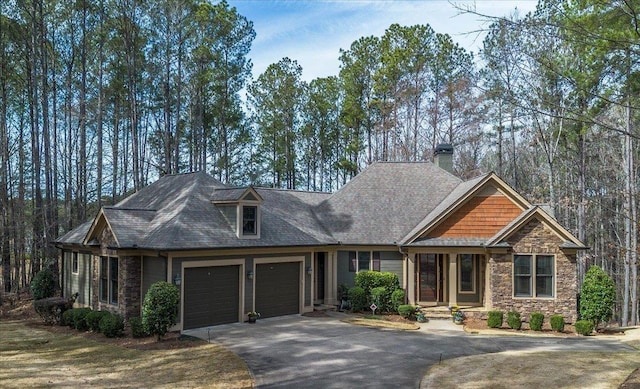 craftsman inspired home featuring an attached garage, stone siding, and driveway