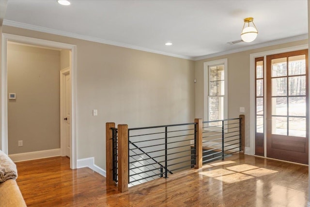 interior space with baseboards, ornamental molding, wood finished floors, and recessed lighting