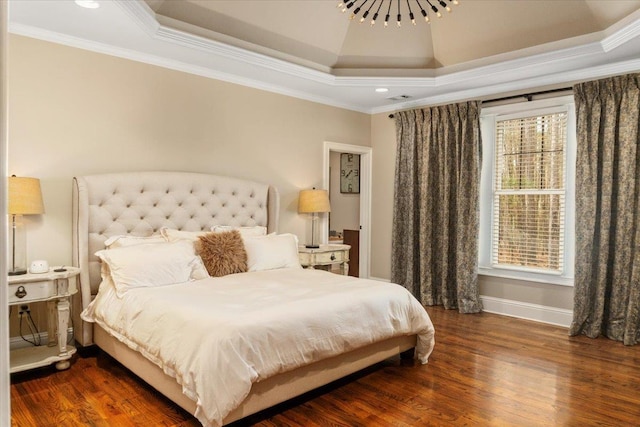 bedroom featuring crown molding, a raised ceiling, visible vents, wood finished floors, and baseboards