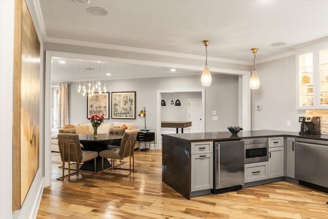 kitchen with stainless steel appliances, dark countertops, light wood-style floors, and a peninsula